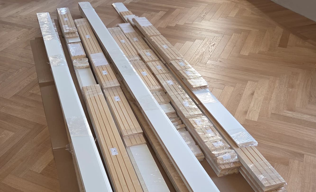 Battiscopa già tagliati, imballati ed etichettati, appoggiati sul parquet del cantiere prima della posa